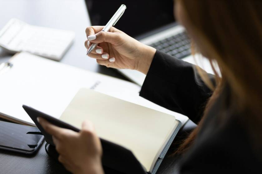Business woman working in an office writes financial and accounting records.