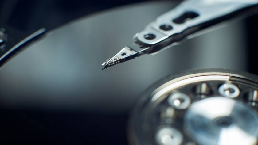 Disassembled hard disk. Read head, magnetic disk and spindle close-up.