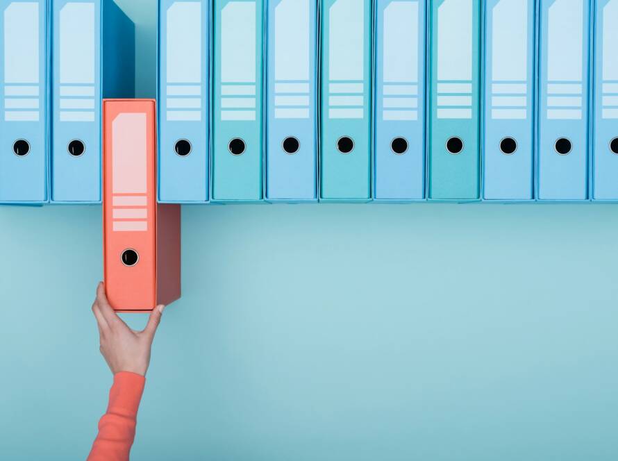 Office worker taking a folder in the archive